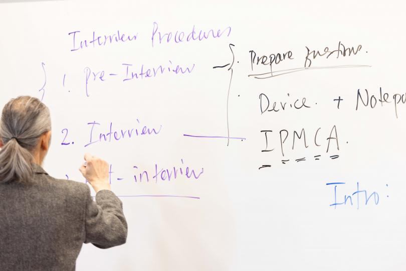 Professor writing on whiteboard